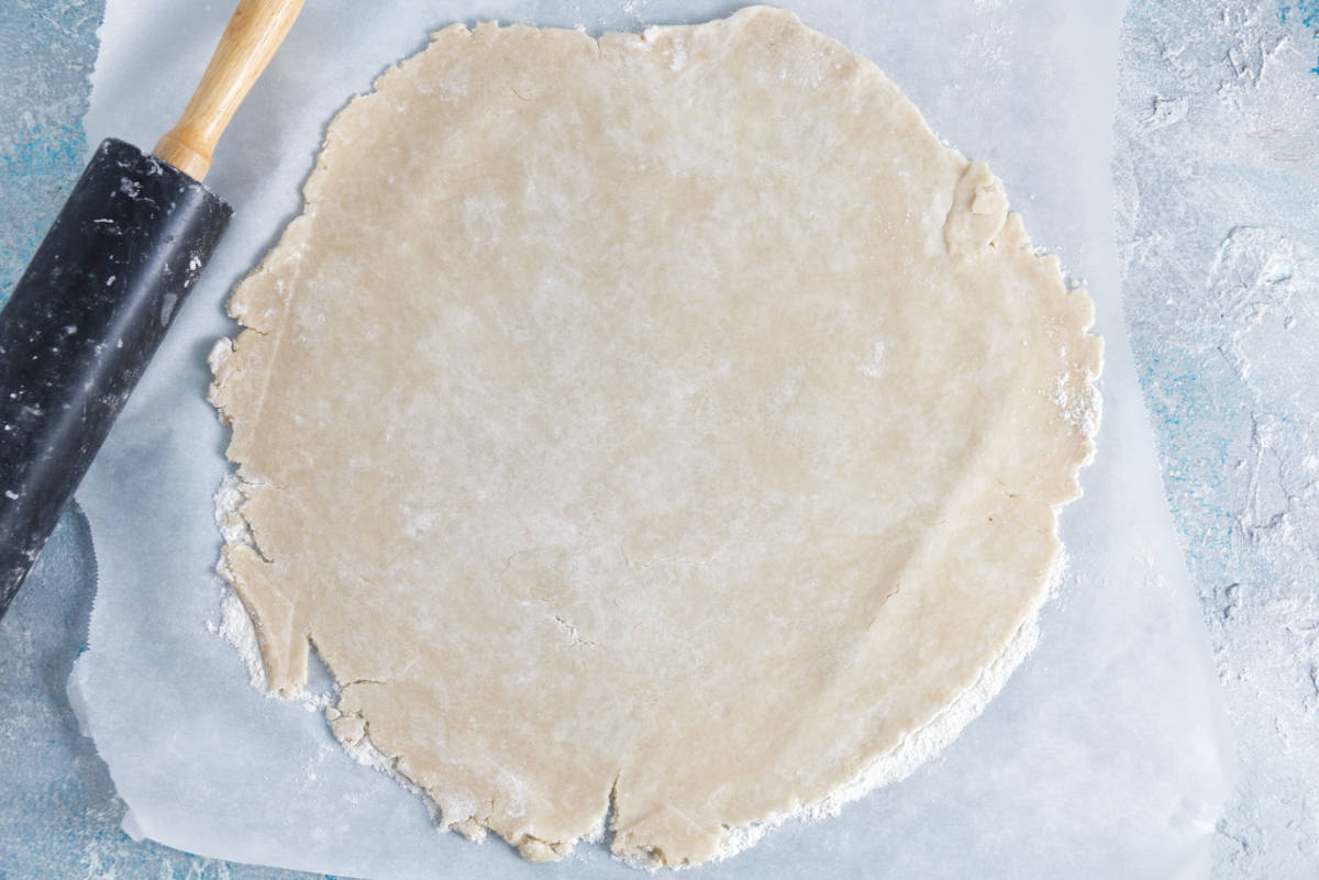 pie crust rolled out thin on parchment paper