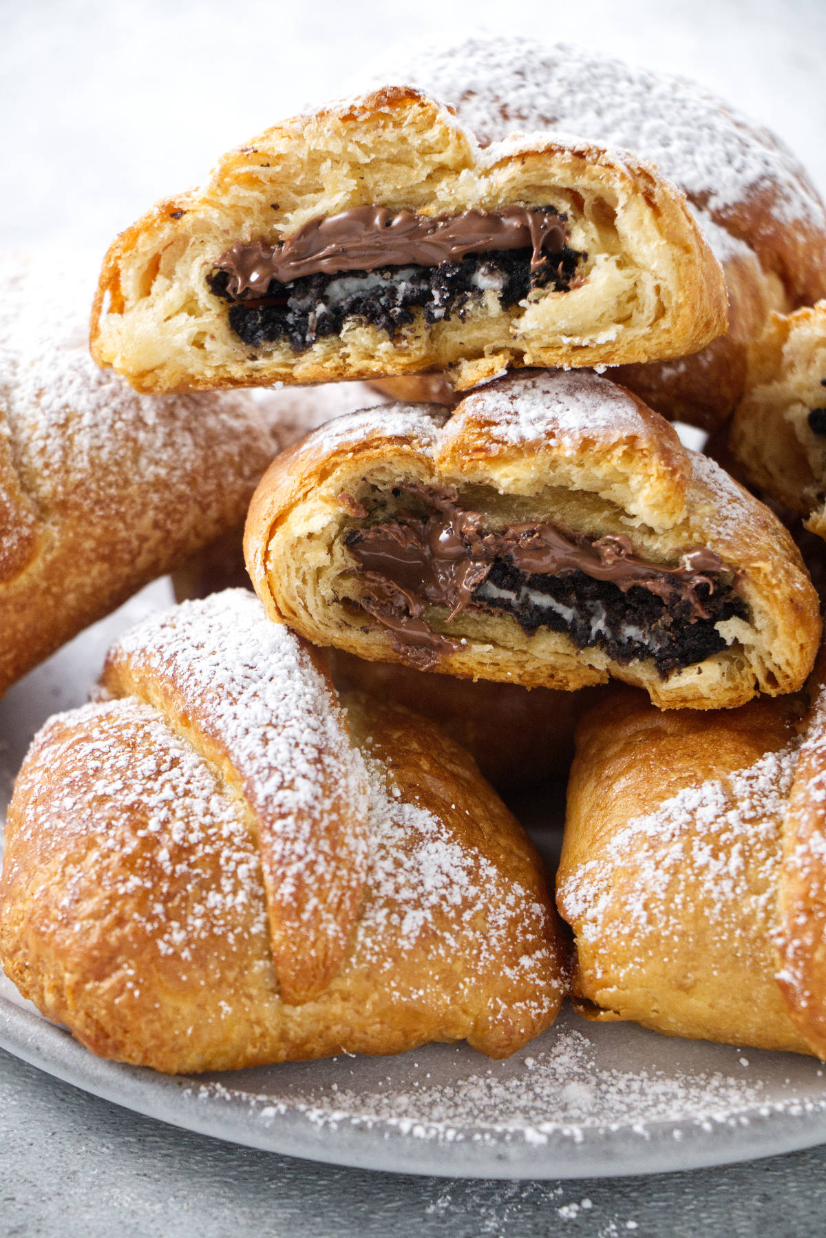 air fried oreos stacked in a pile and dusted with powdered sugar.