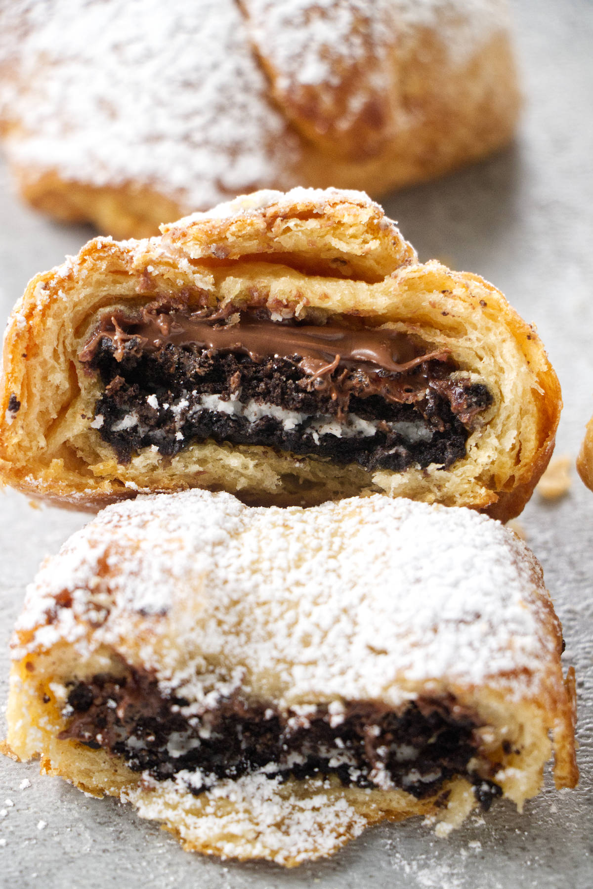 Two air fried oreos that have been bitten into with chocolate nutella dripping out.
