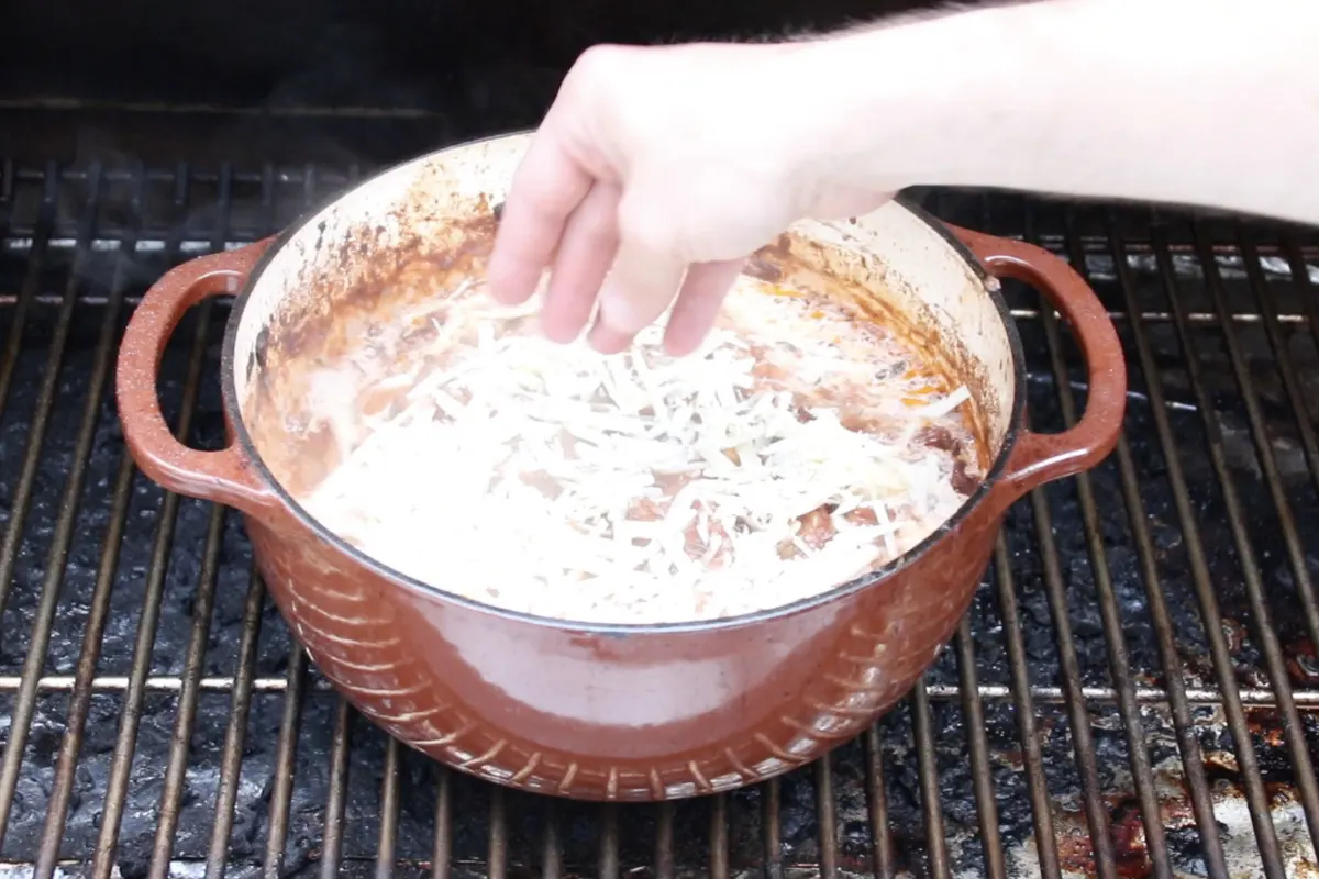 adding parmesan cheese to ragu in dutch oven