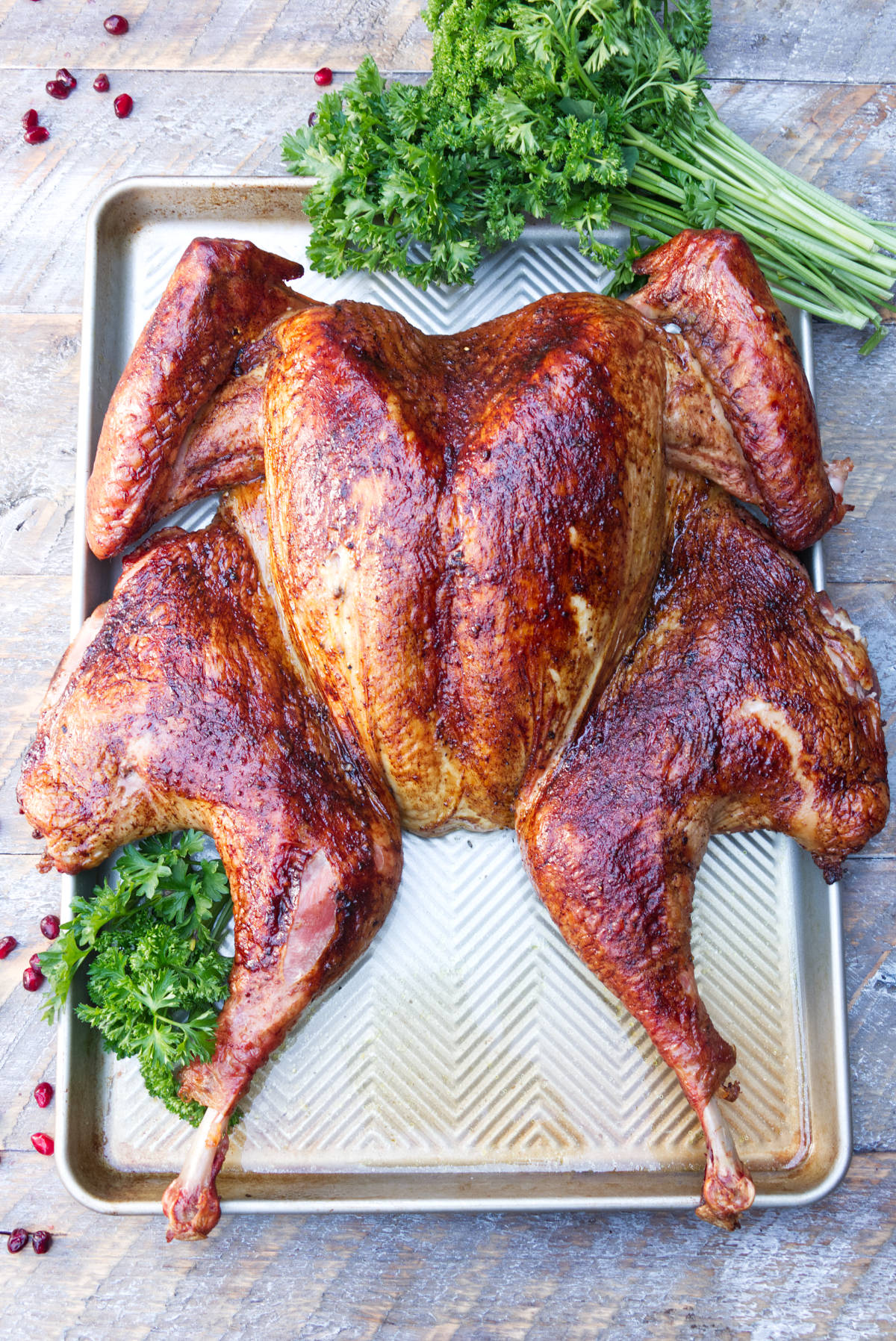 Smoked spatchcock turkey on baking sheet ready to be carved