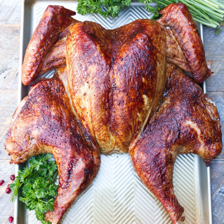 Smoked spatchcock turkey on baking sheet ready to be carved