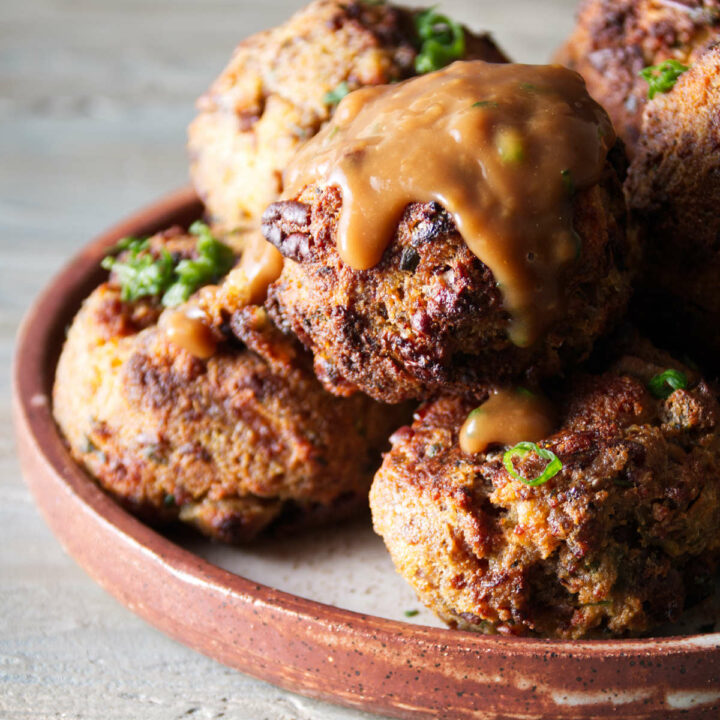 stuffing balls on a plate with gravy poured over