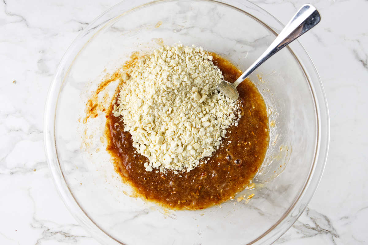 Adding bread crumbs to mixing bowl for meatloaf.