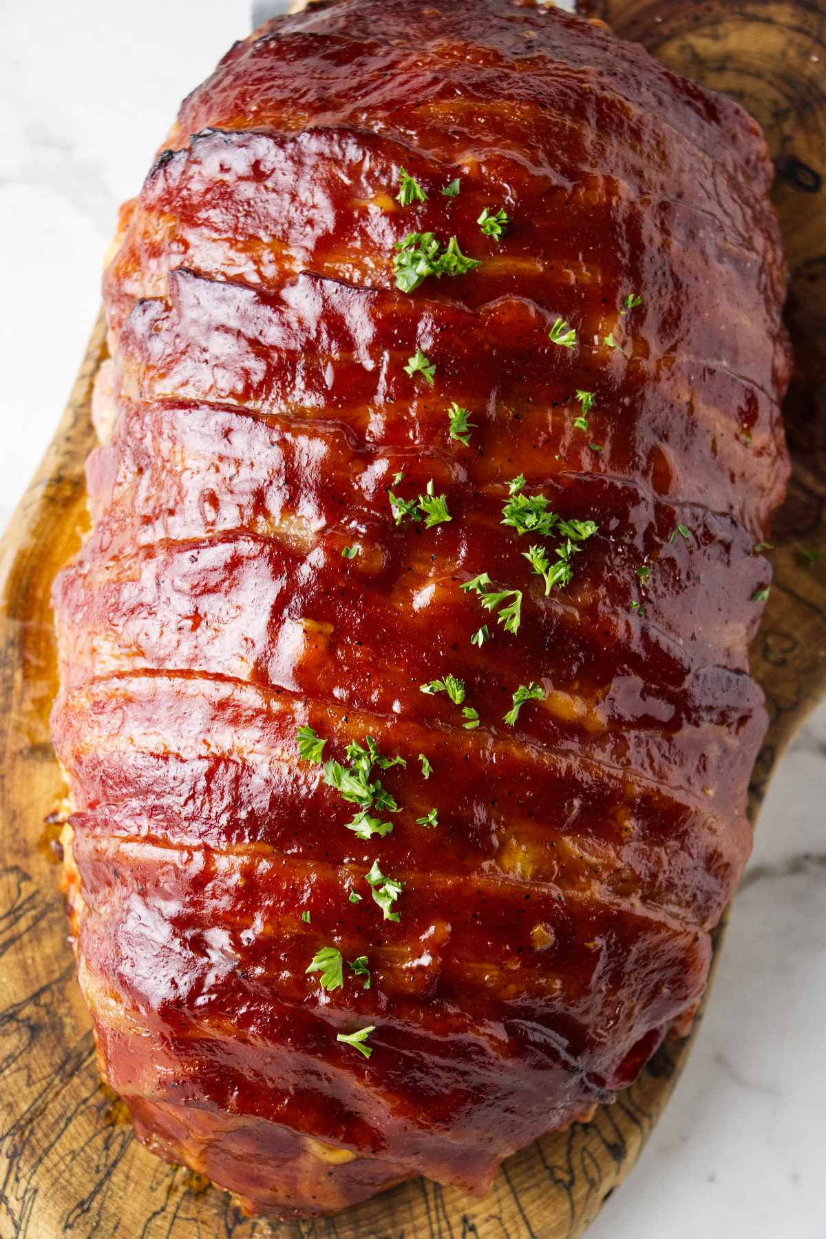 Traeger smoked bacon wrapped meatloaf on a cutting board