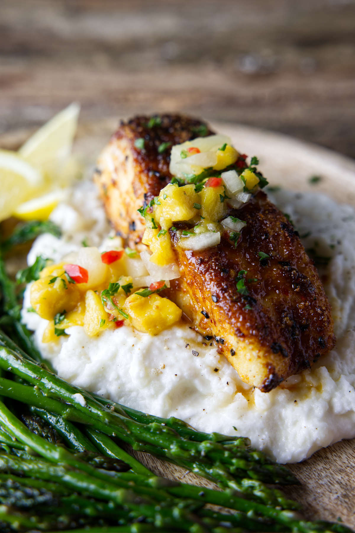 perfectly cooked halibut fillet with mango pineapple salsa on top