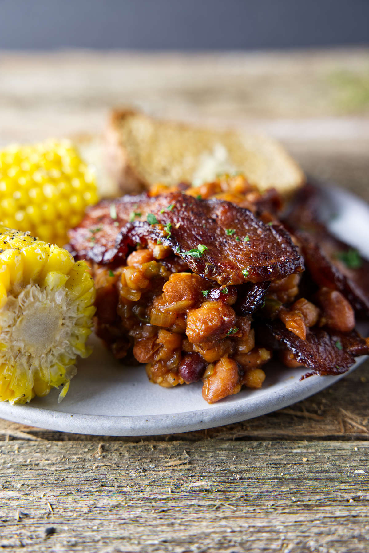 plate with baked beans and a thick slice of bacon on top