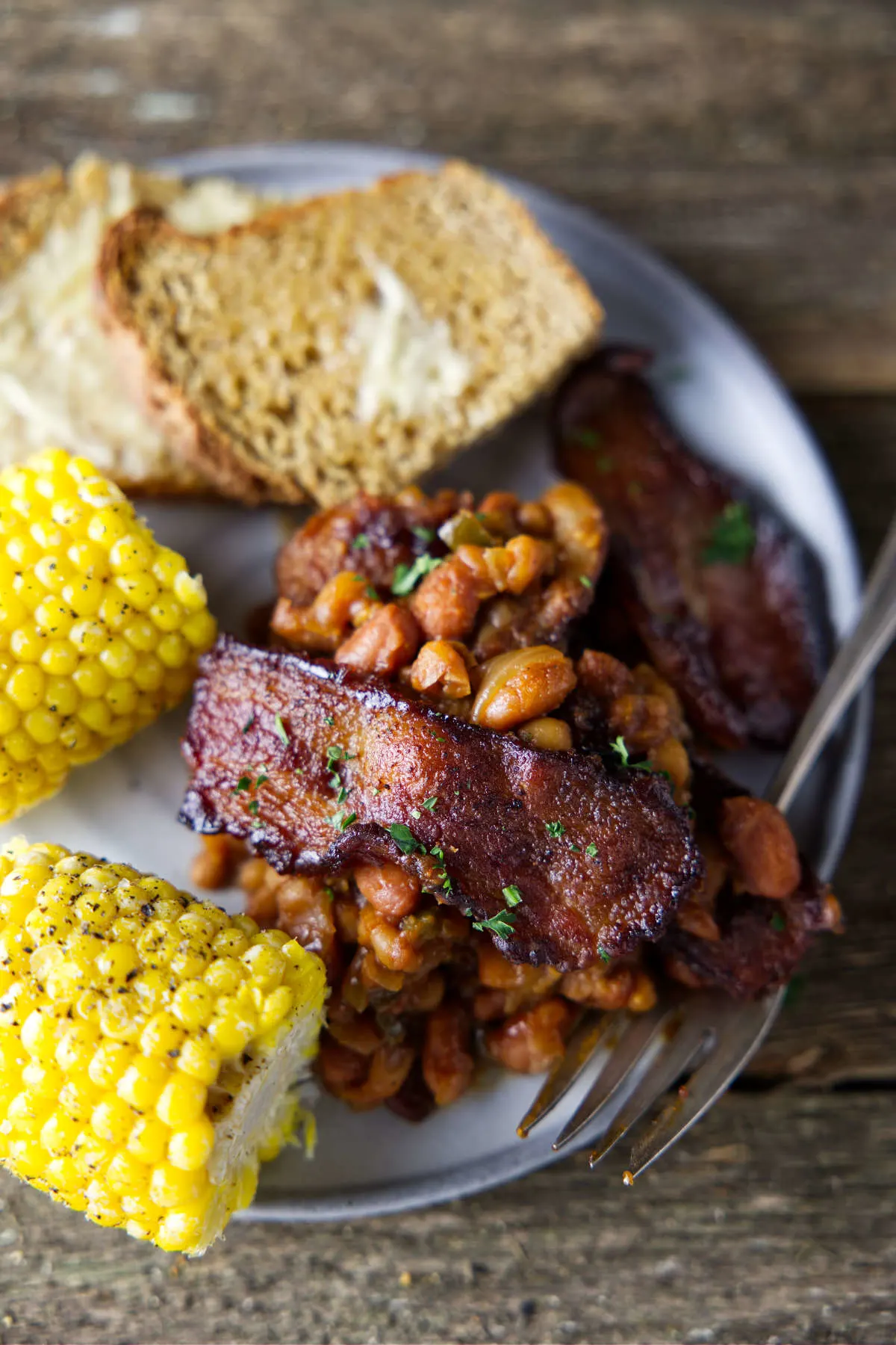 baked beans on a plate with corn and bread