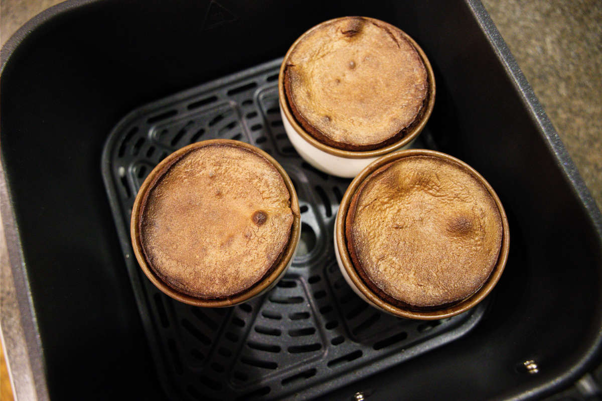 Chocolate mug cakes in air fryer basket.