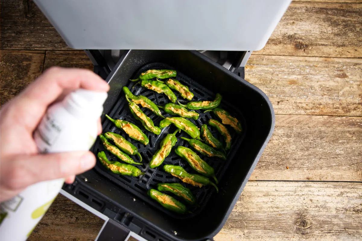 stuffed shishito peppers in an air fryer basket