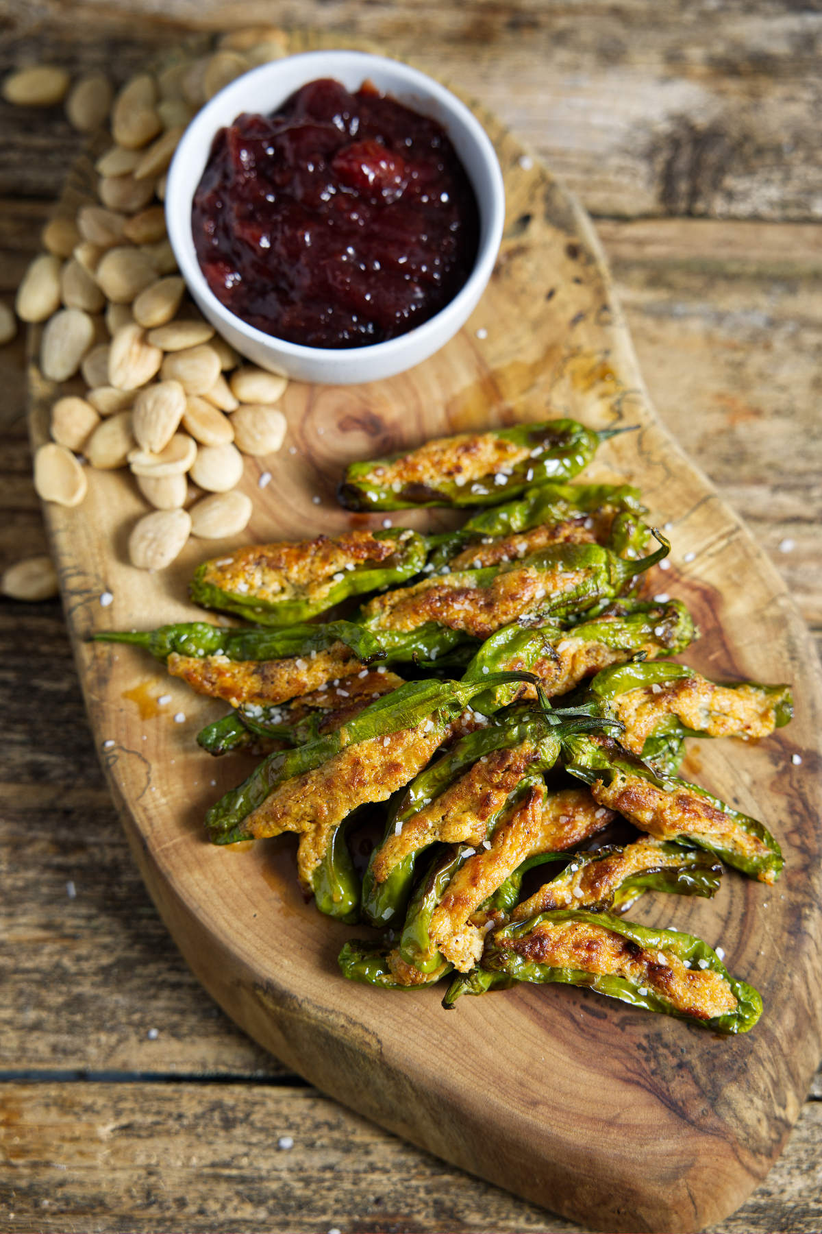 air fryer shishito peppers on cutting board with cherry preserves and almonds