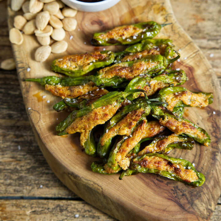 air fryer shishito peppers on cutting board with cherry preserves and almonds