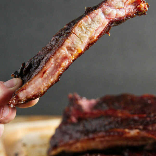 traeger smoked pork spare ribs, sliced and one being held
