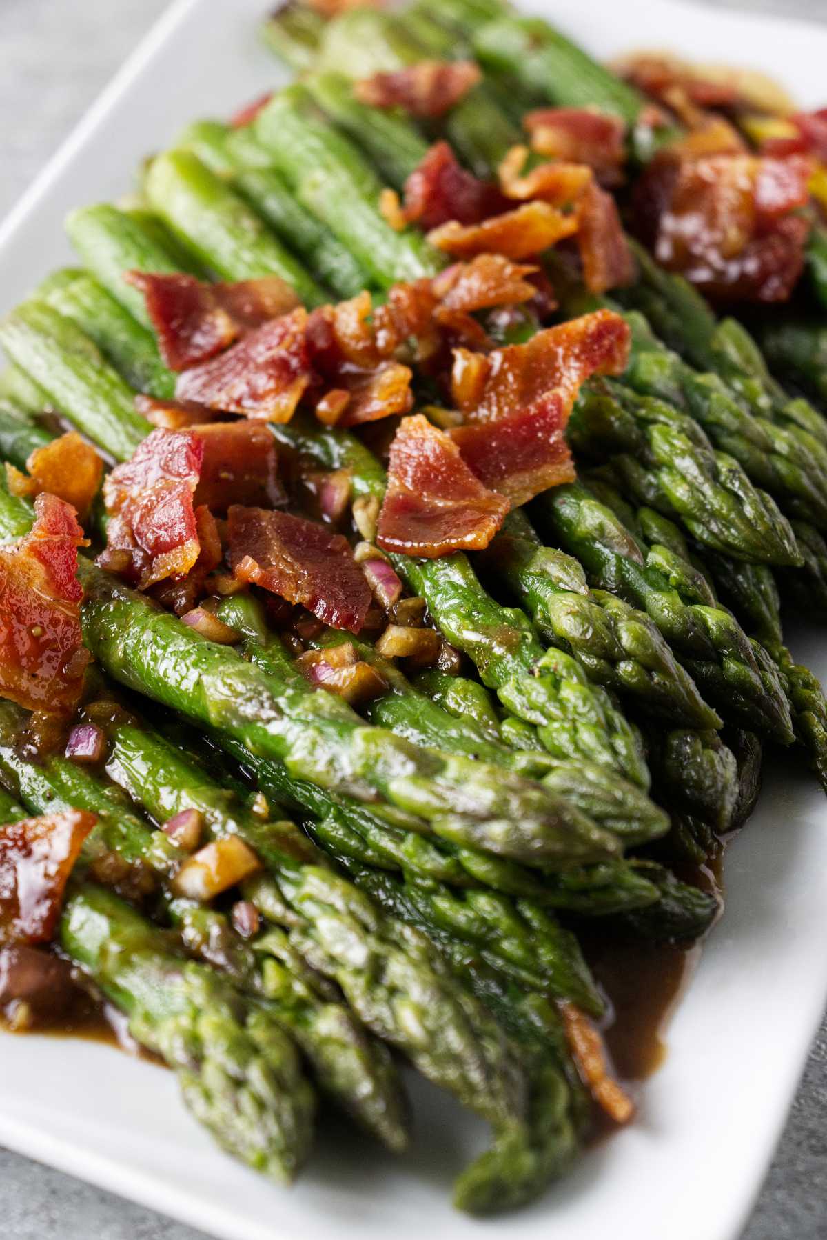 Frozen asparagus cooked in an air fryer and plated with crumbled bacon and a vinaigrette.