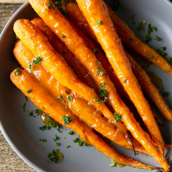 smoked carrots in a bowl with glaze drizzled over the top