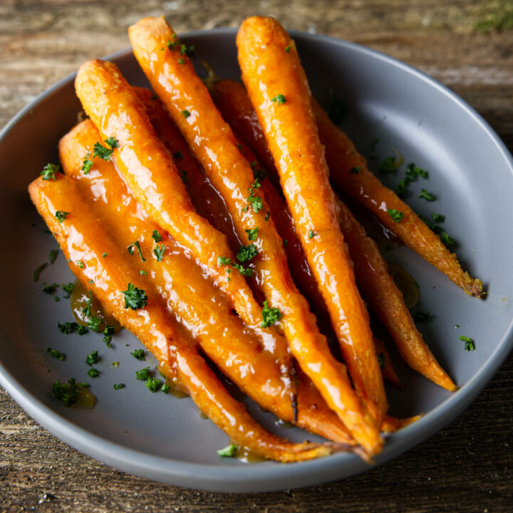 smoked glazed carrots in a bowl with lots of glistening glaze on top