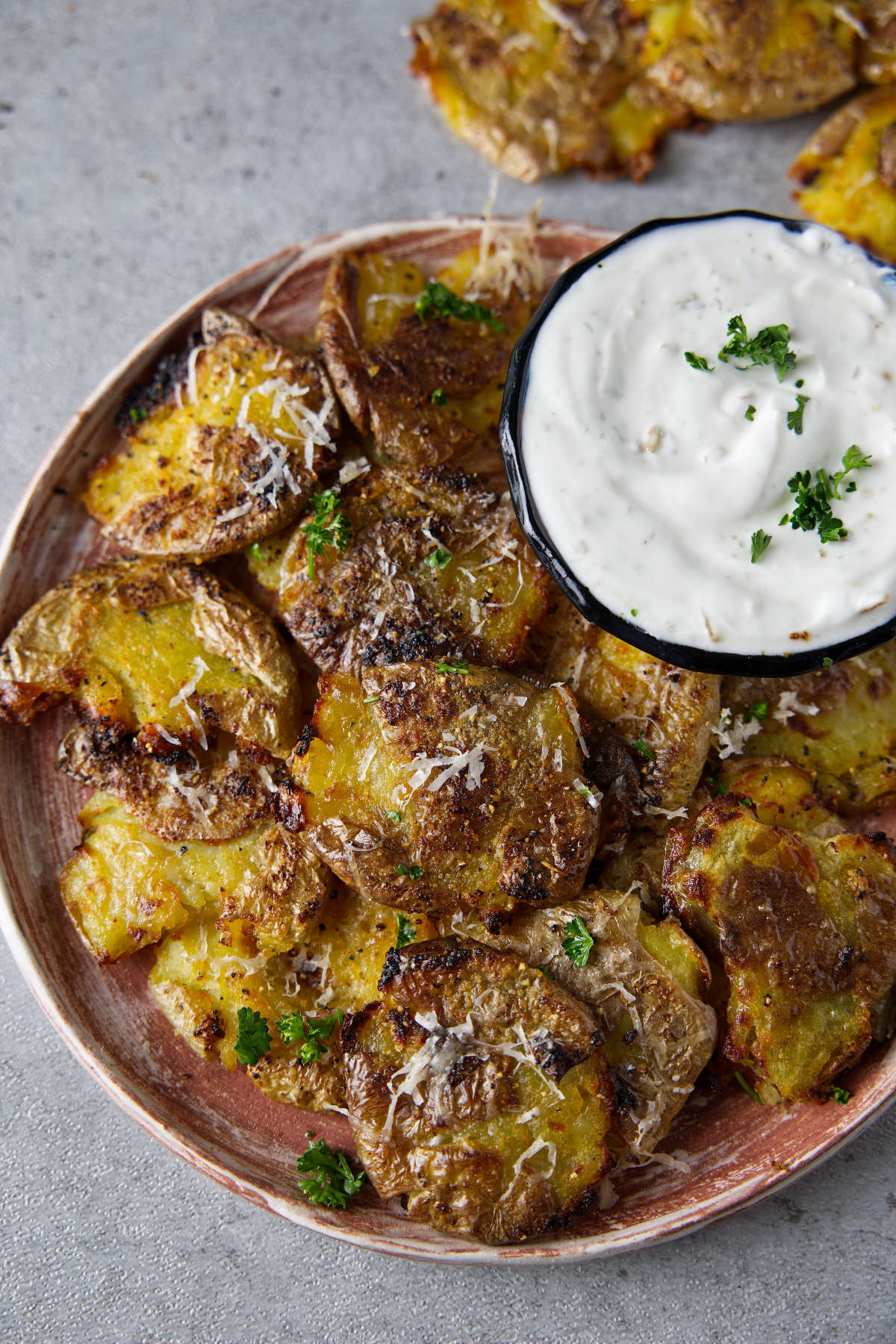 air fryer smashed potatoes plated with a bowl of dipping sauce