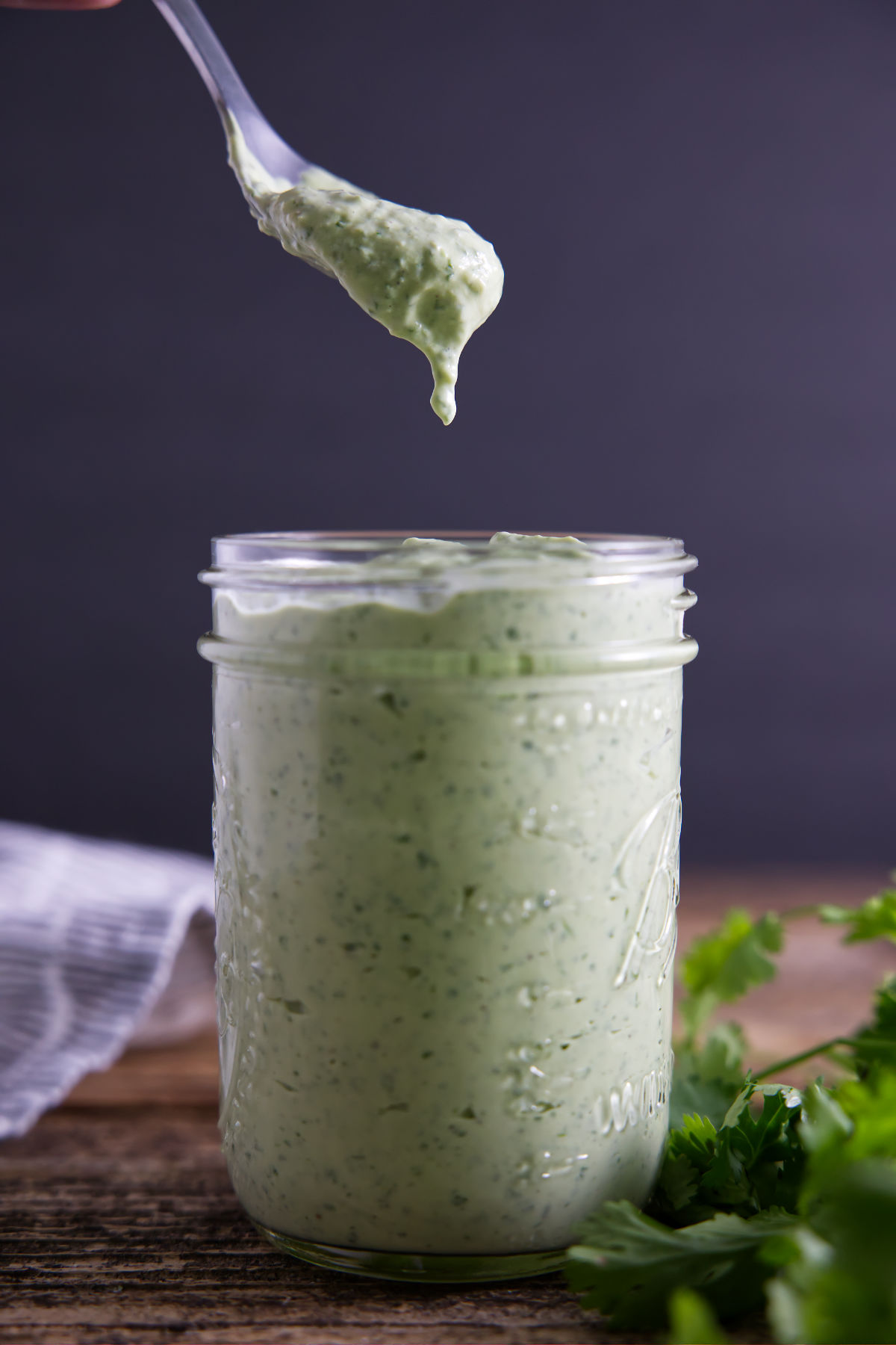 Spoon full of avocado crema sauce straight from the jar.