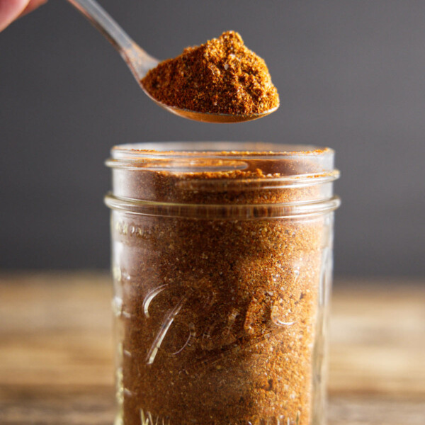 pork butt rub in mason jar with a spoon full hovering over