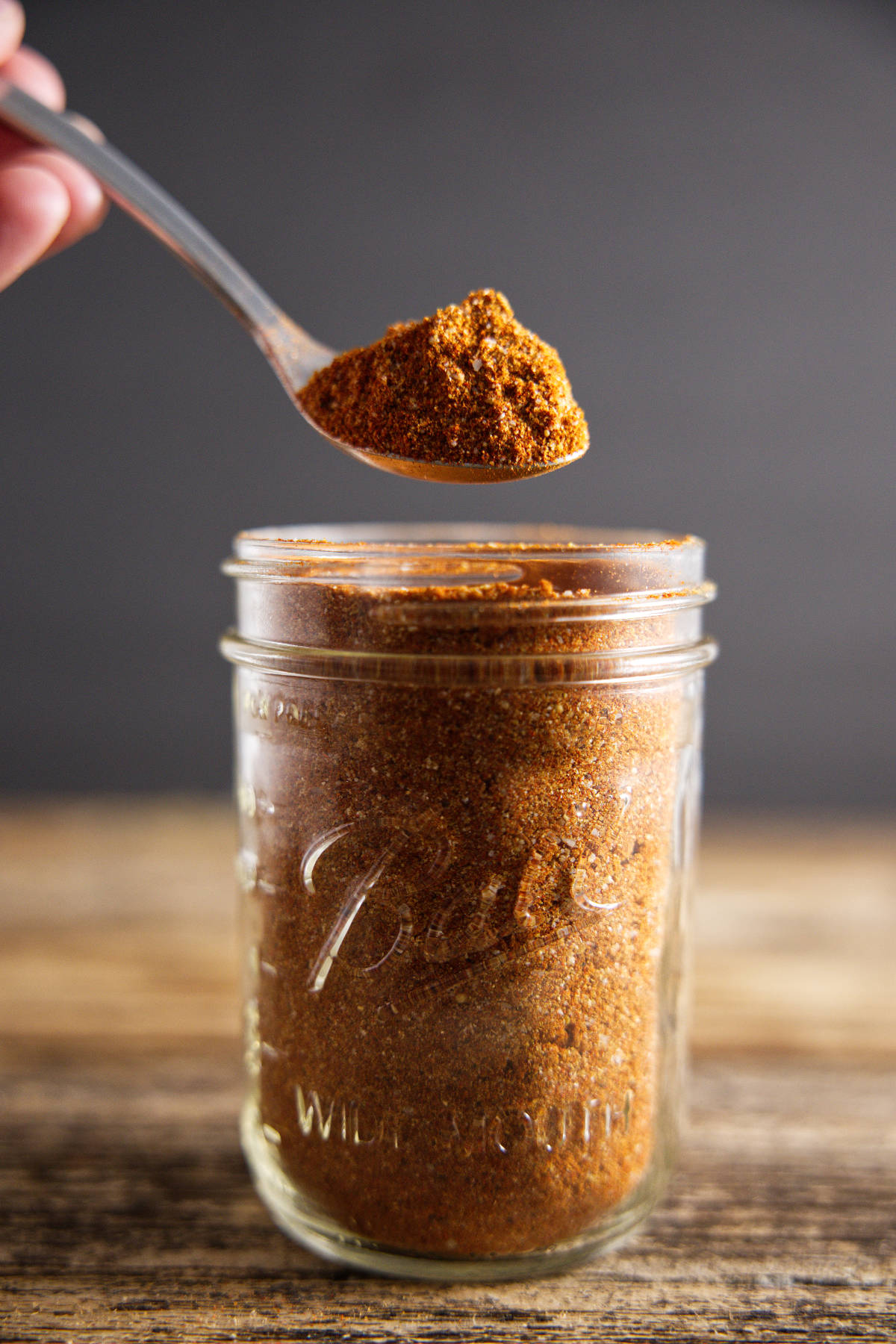 pork butt rub in mason jar with a spoon full hovering over