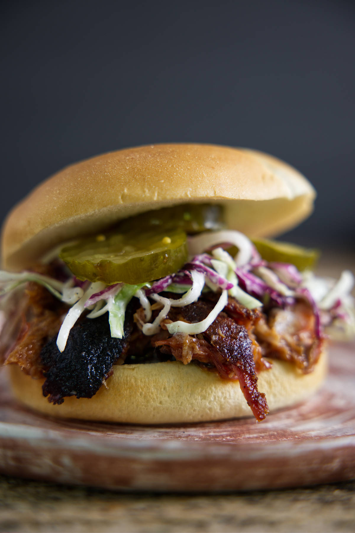 Pulled pork sandwich with slaw and pickles.