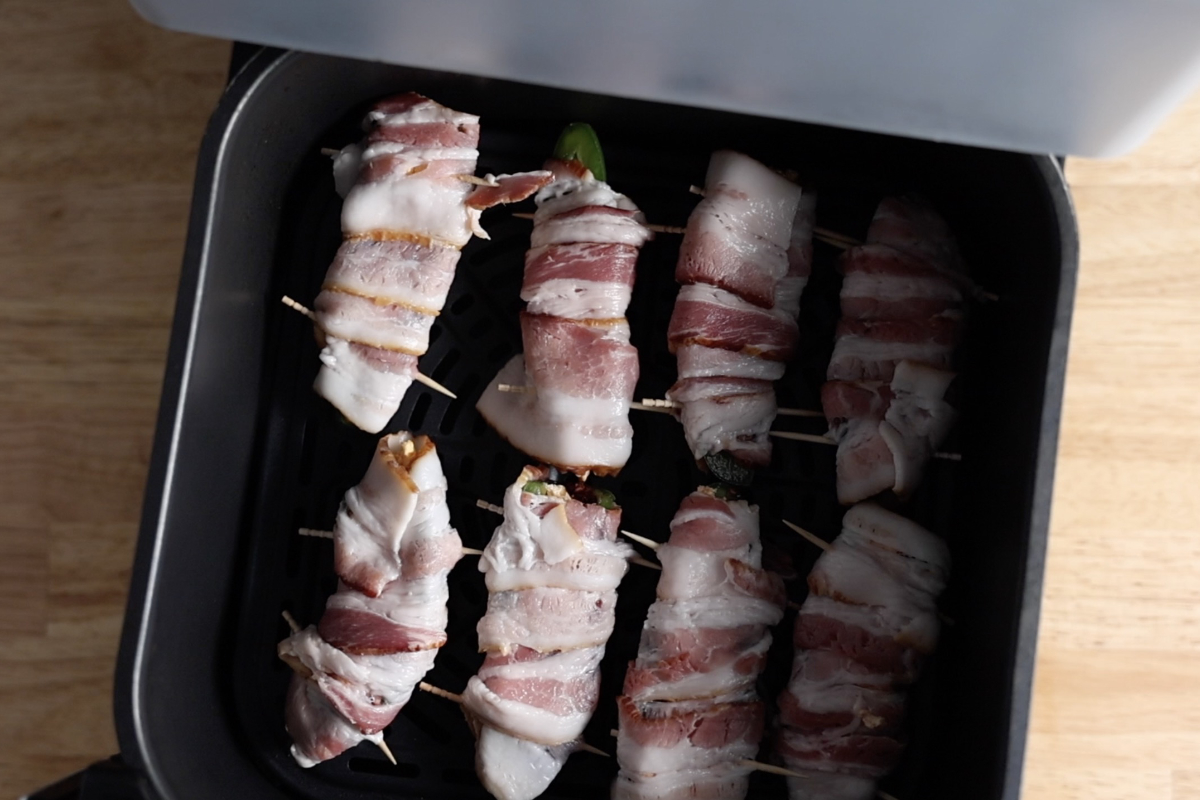 Cooking air fryer bacon wrapped jalapeno poppers in an air fryer.
