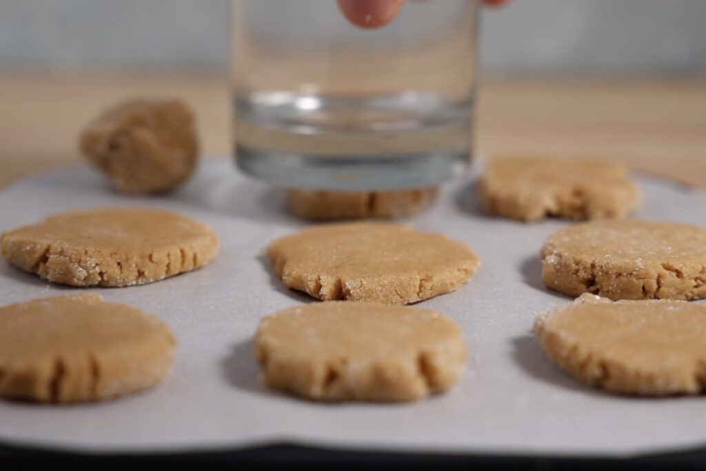 Flattening cookies with glass.