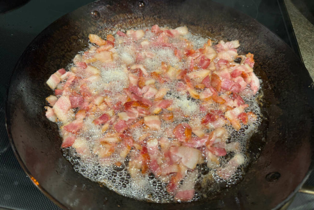 Cooking bacon in a fry pan.