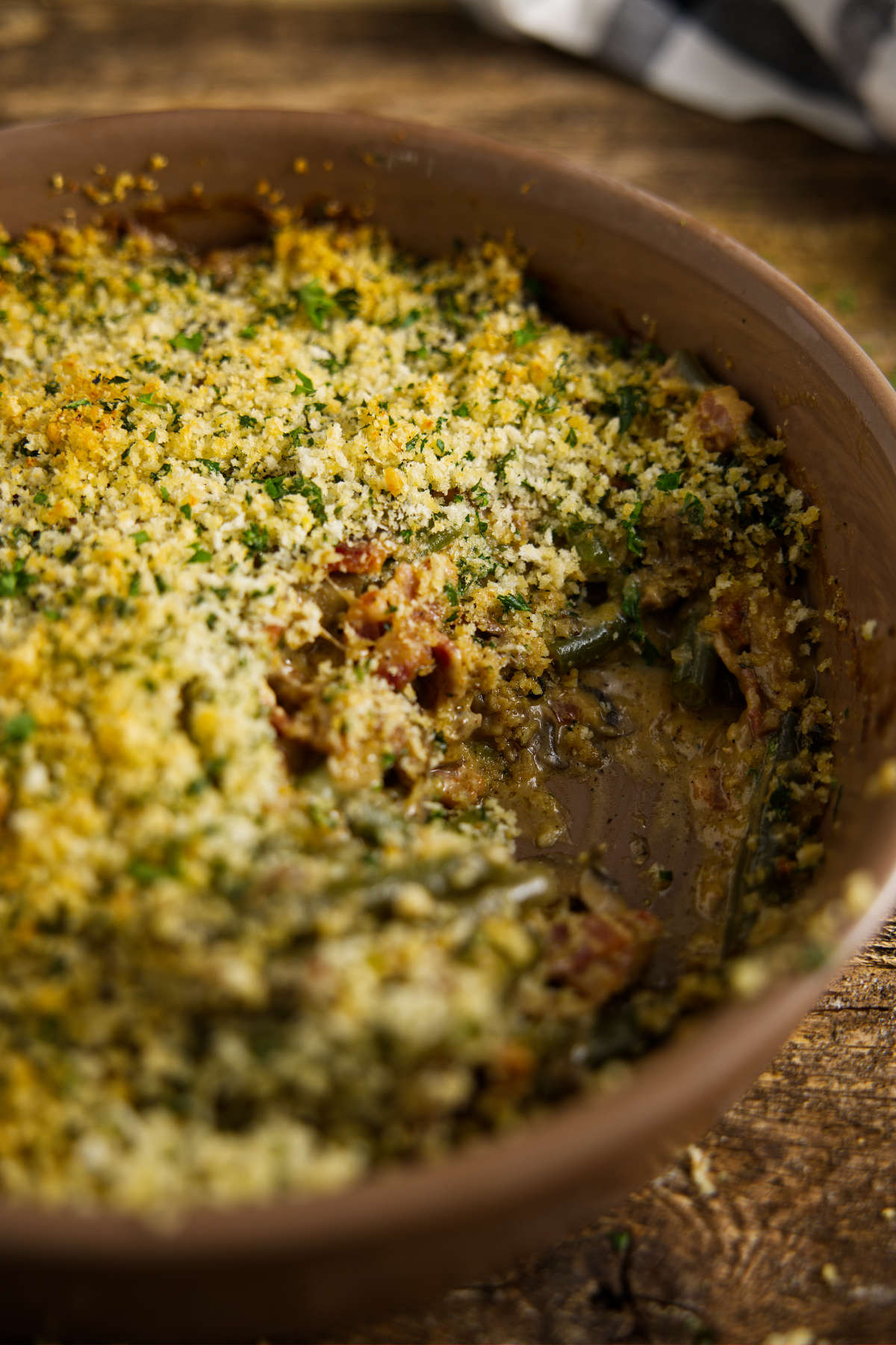 Scoop missing from casserole dish of smoked green bean casserole.