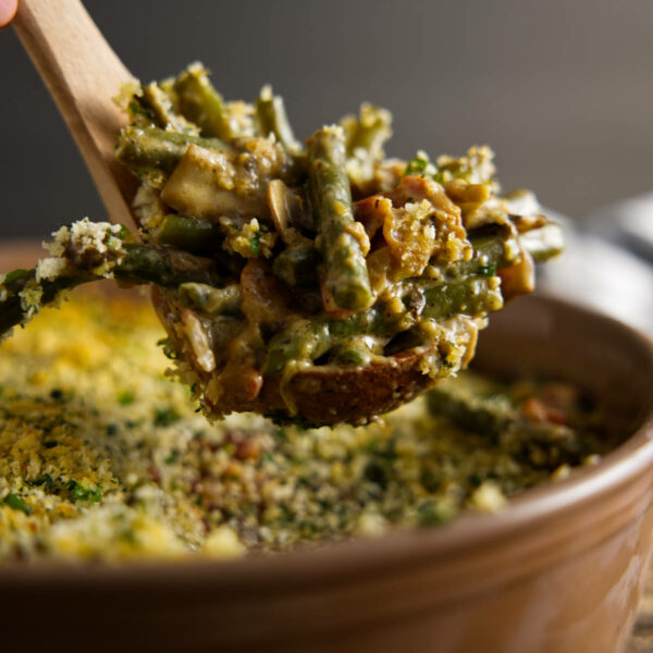 Large scoop from casserole dish of smoked green bean casserole.