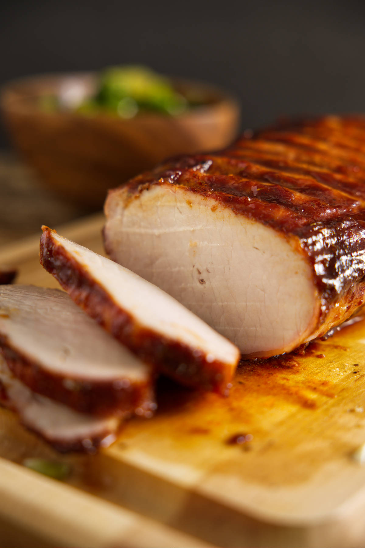 How to - BBQ pork loin sliced and resting on cutting board.