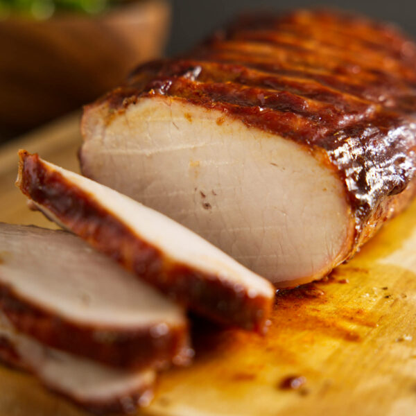 How to BBQ pork loin, whole pork loin sliced on cutting board.