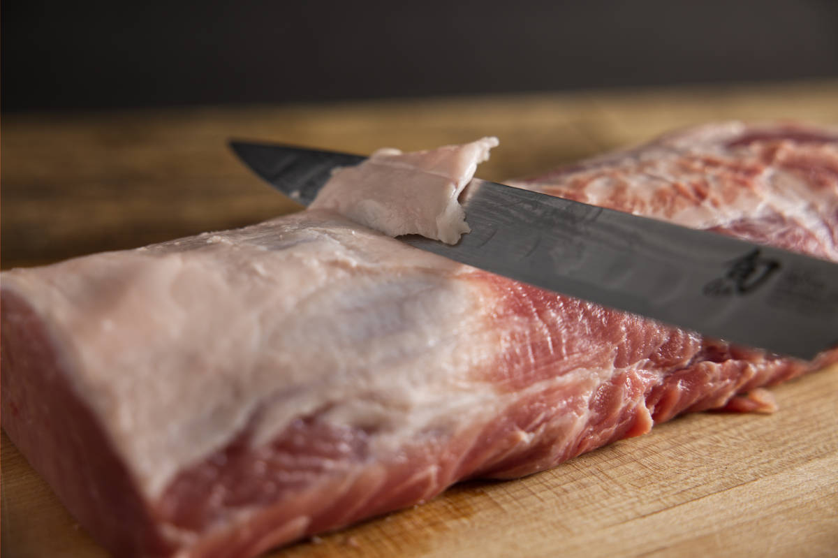 Trimming excess fat from pork loin.