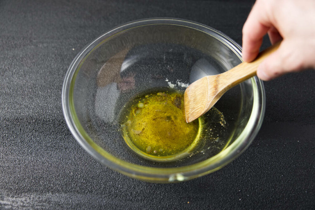 Mixing together the seasoning and liquid ingredients for the avocado salsa in a large glass bowl.