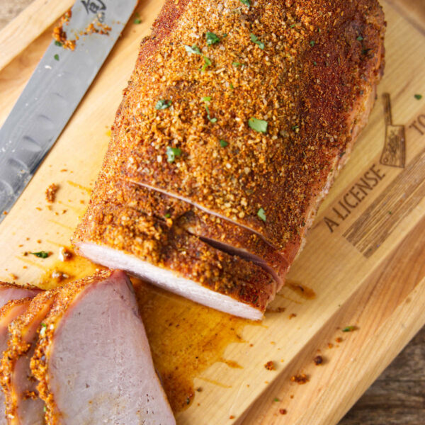 Sliced smoked pork loin on cutting board.
