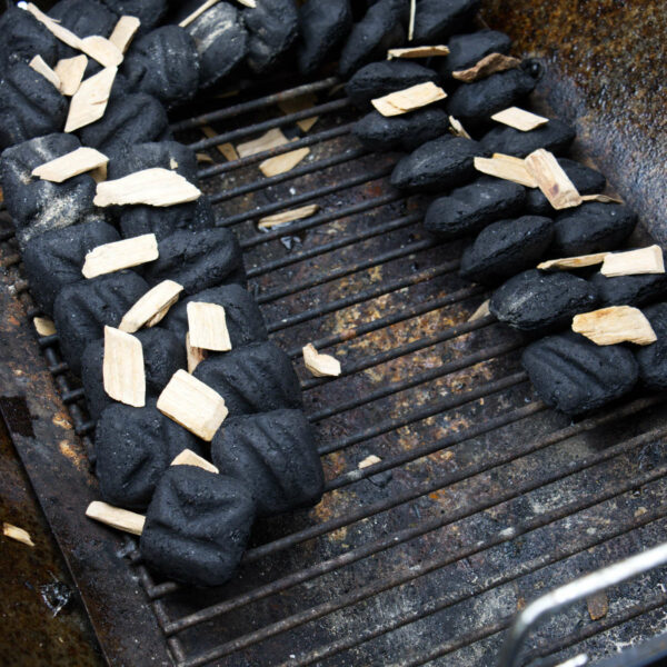 Charcoal arranged in a snake around the perimeter of the grill.