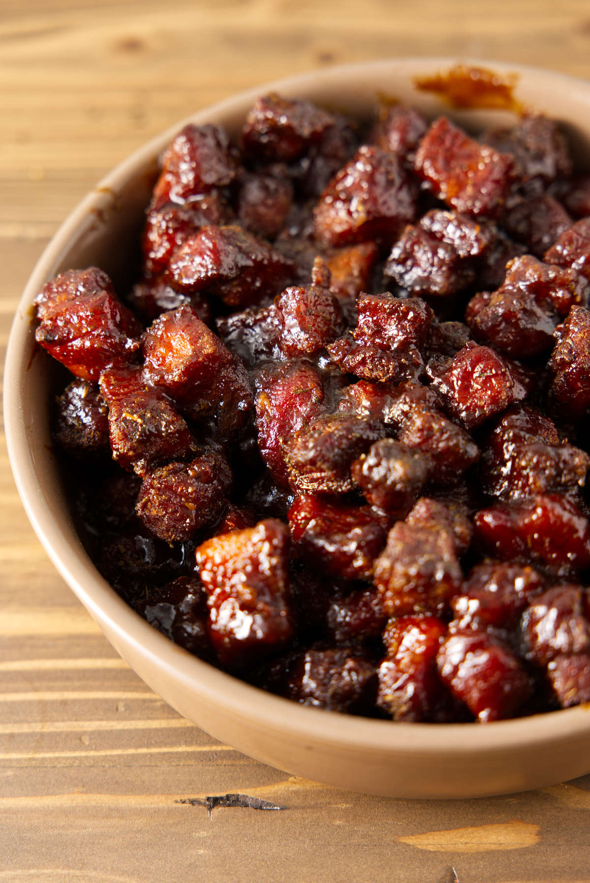 Pork belly burnt ends in a larger ceramic bowl.