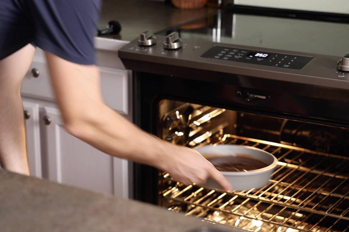 Placing cake in the oven to bake.