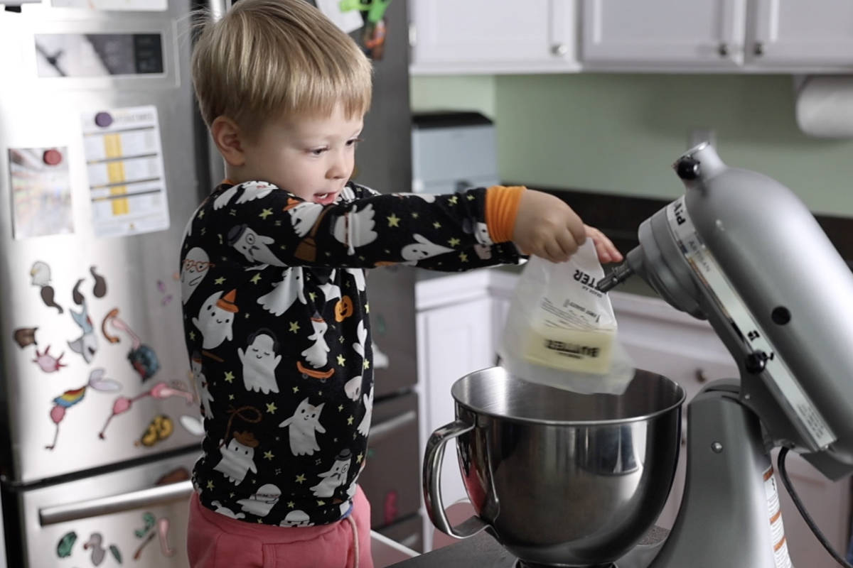 Adding a stick of butter to a stand mixer.