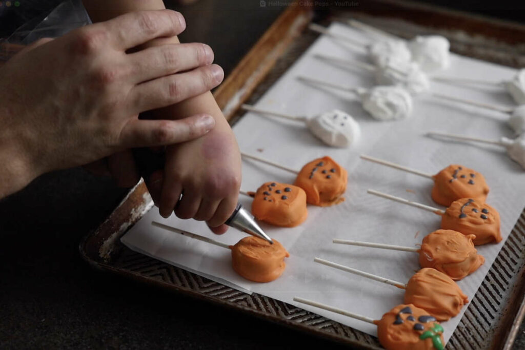 Decorating cake pops with icing.