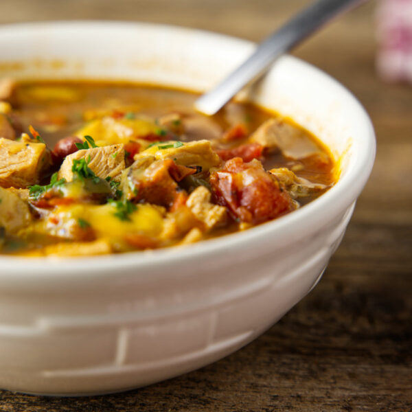 Bowl of chili with turkey and tomatoes and a sprinkle of chopped parsley.