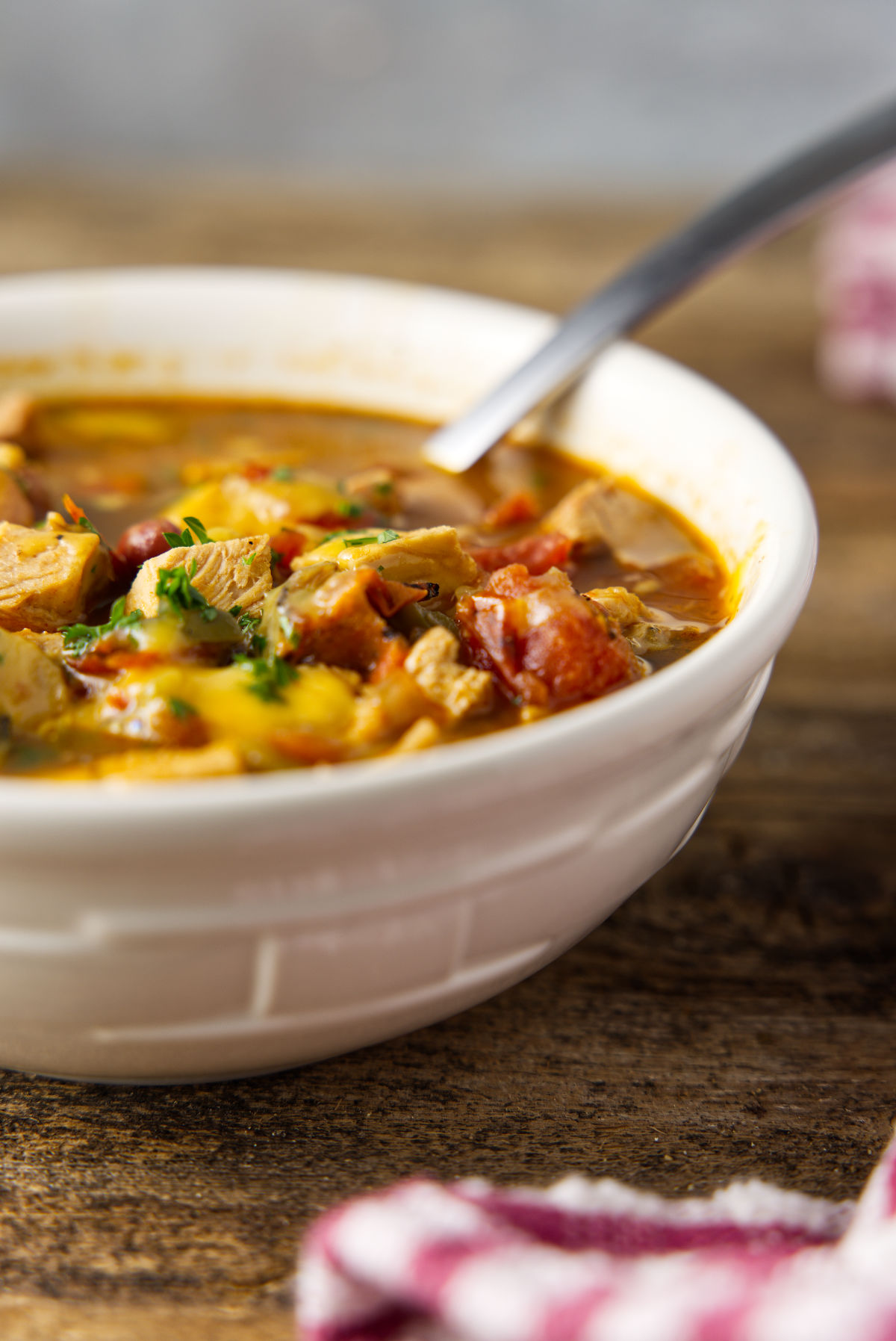 Bowl of chili with turkey and tomatoes and a sprinkle of chopped parsley.