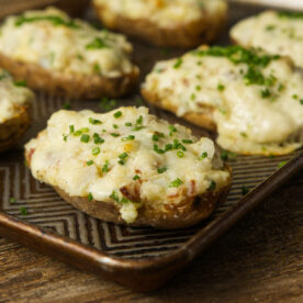 Twice baked potatoes with gooey cheese and topped with chives.