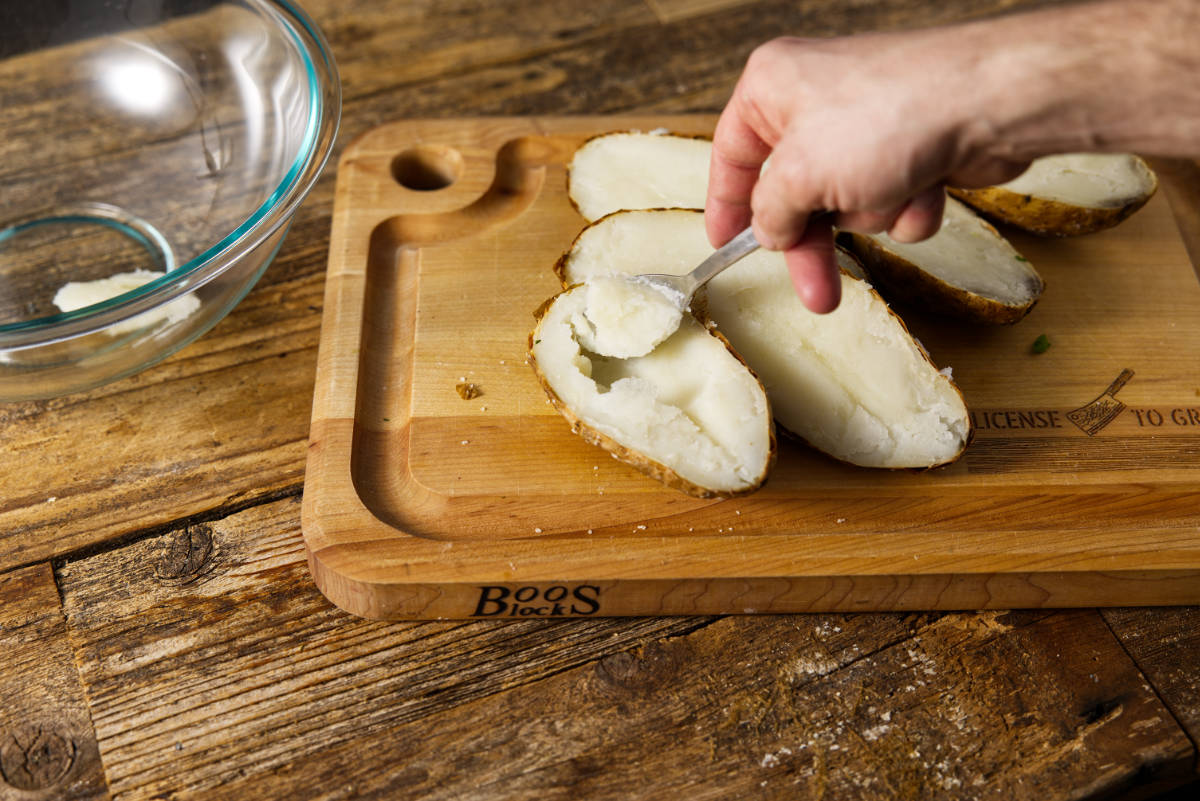 Scooping out the potatoes from the skin.