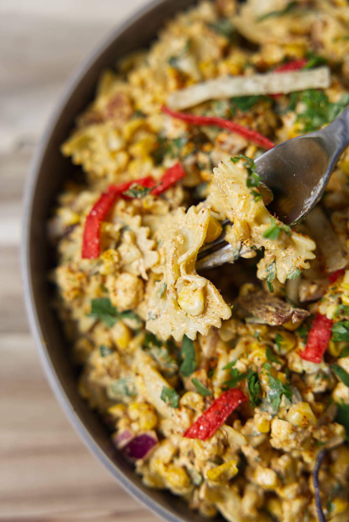 Vibrant tortilla chips and tajin sprinkled on top of the street corn pasta salad.