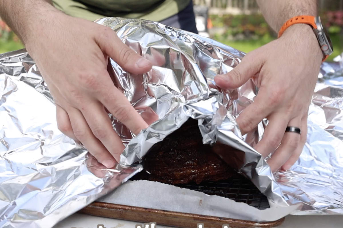 Putting foil over the double smoked ham before letting it rest.