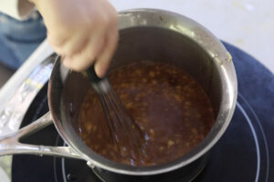 Simmering the glaze in a medium saucepan.