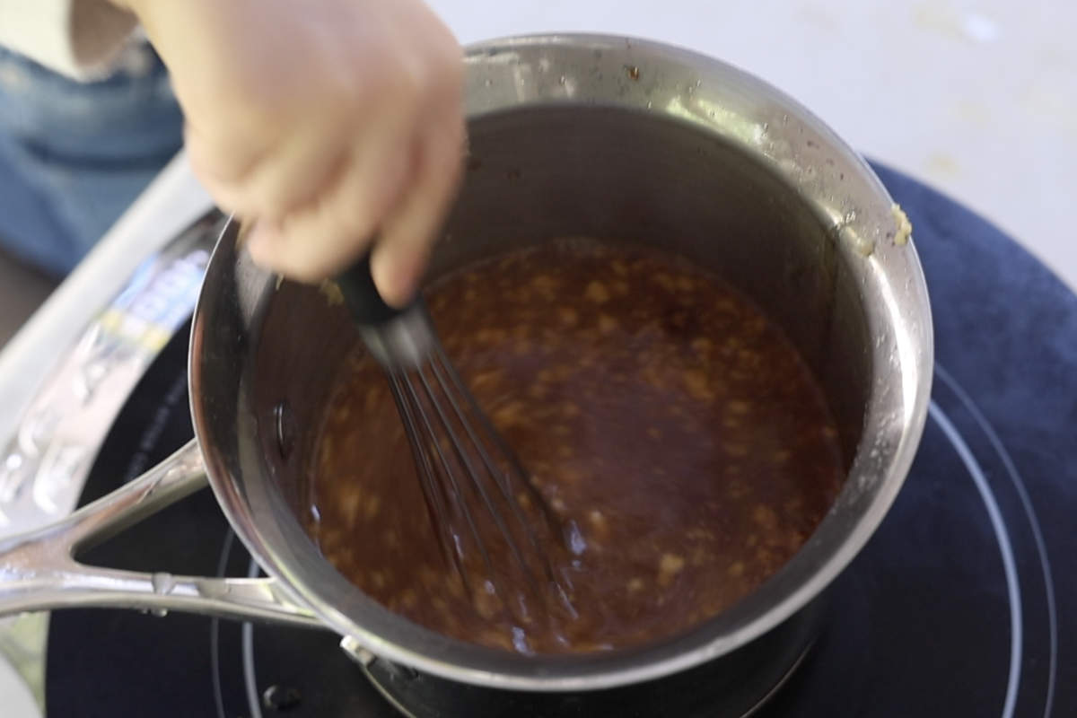 Simmering the glaze in a medium saucepan.