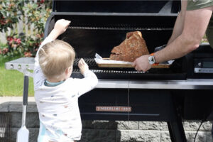 Placing spiral cut ham on the smoker.