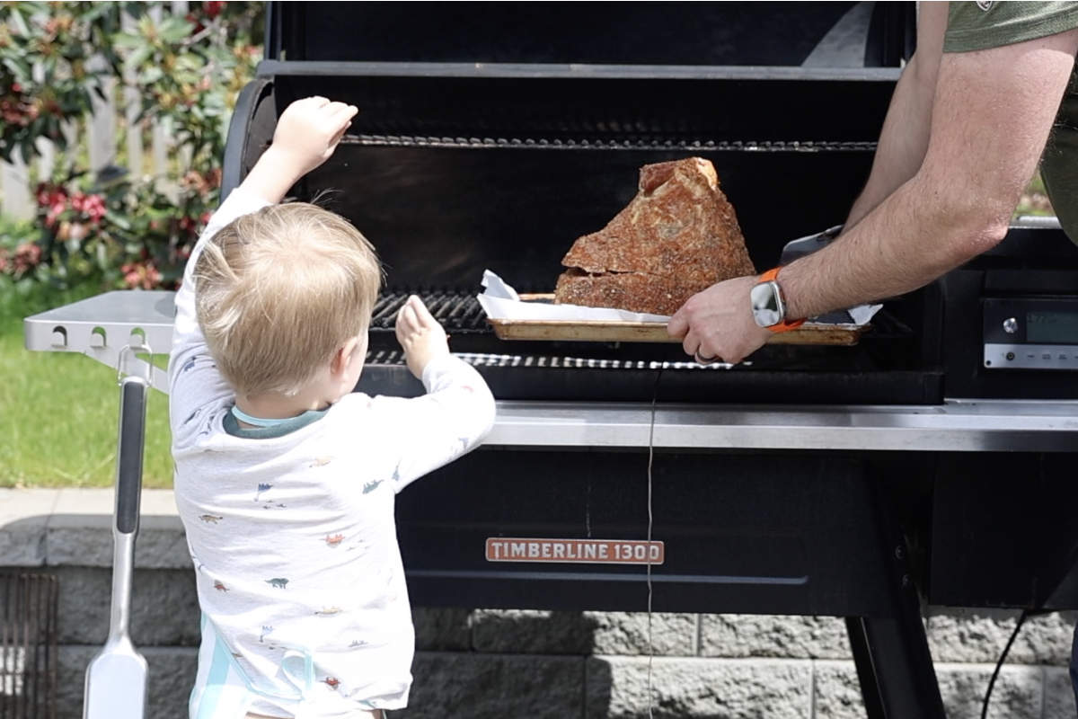 Placing spiral cut ham on the smoker.